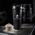 Black Shaker bottle with Blackspire logo on a dark surface with protein powder.