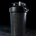 Black shaker bottle with measurement markings on a dark background